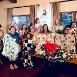 Women showing blankets they made for newborns