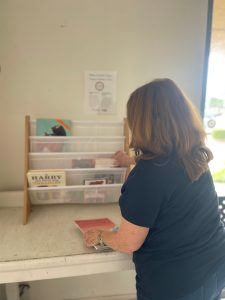 Liz is restocking children's books at Village Laundromat