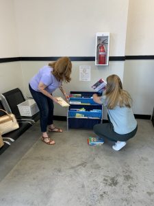 Kati and Liz adding books to the shelf