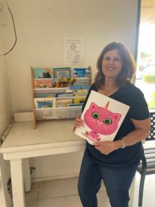 Liz is restocking children's books at Village Laundromat